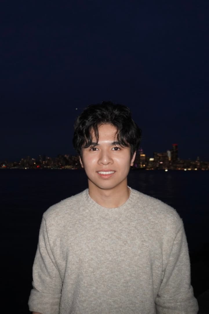 Portrait of Ethan Tandio standing by the water at night
