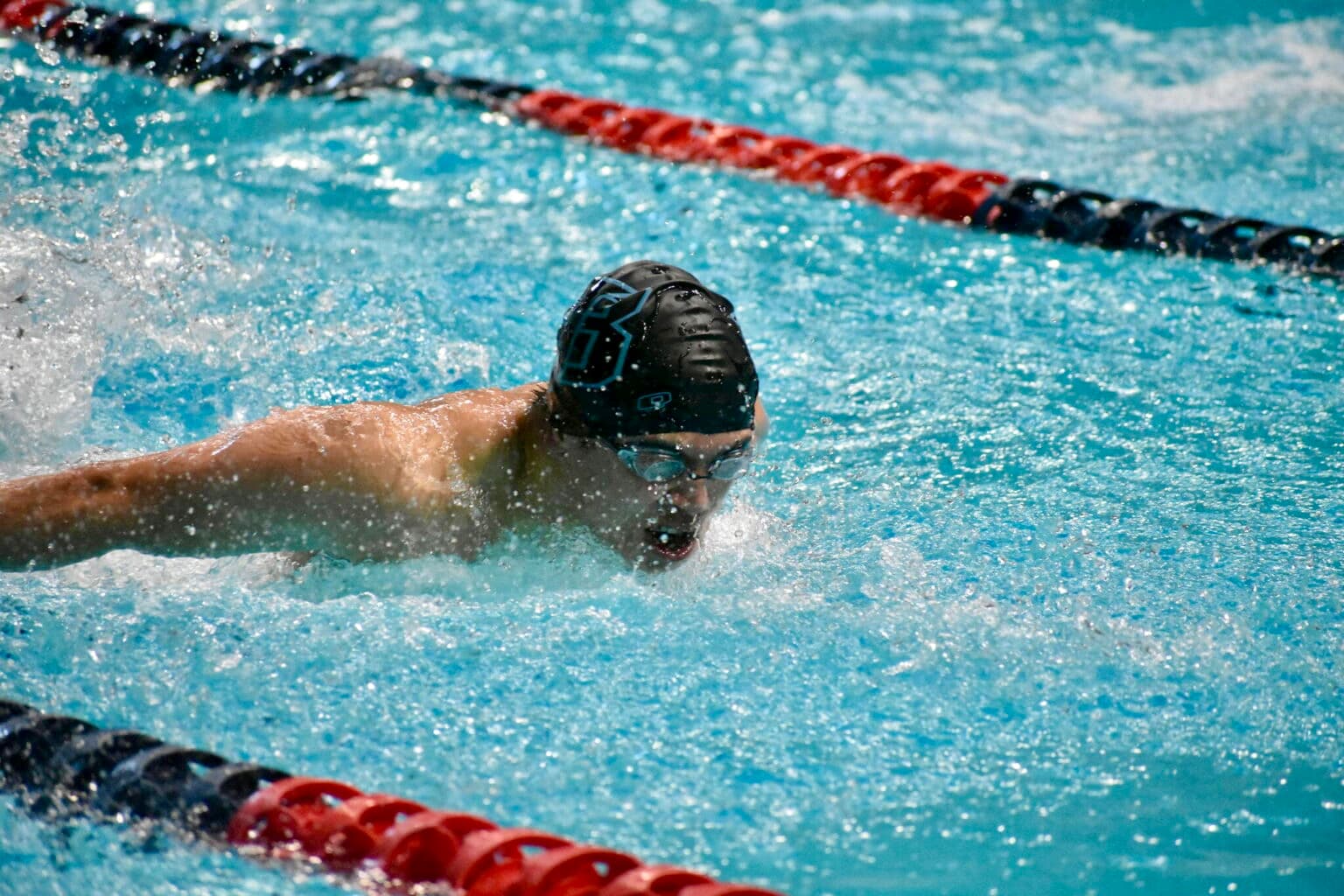 Ethan swimming butterfly in a competitive pool